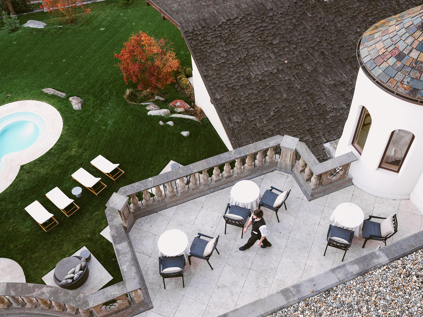 An aerial view of a patio area with a pool and lounge chairs.