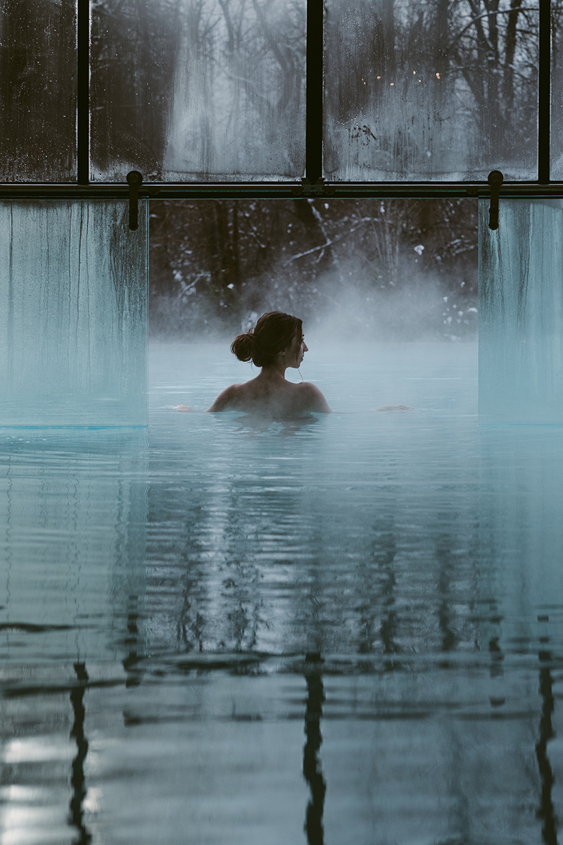 A person in a pool with a window in the background