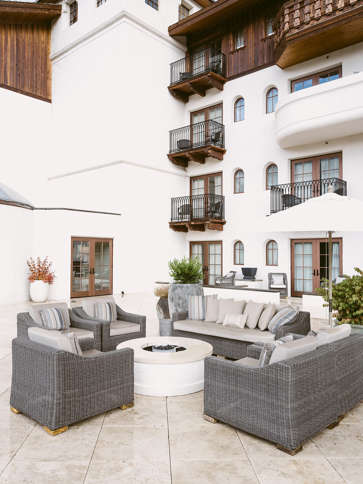 A courtyard with outdoor seating, a fire pit, and a view of the hotel's balconies.